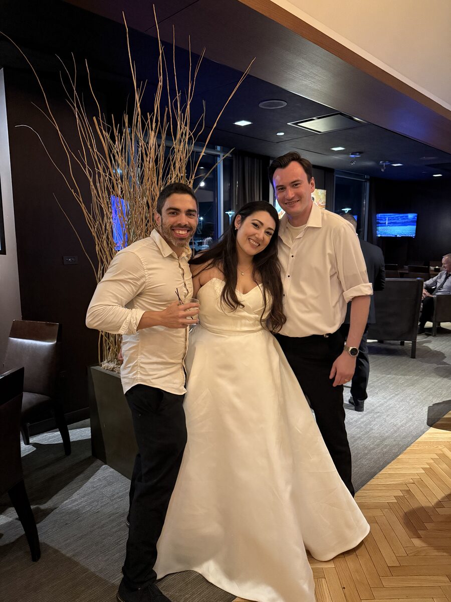 DJ Fidel smiling with newlyweds Alexis and Bryan after their Hotel Arista reception