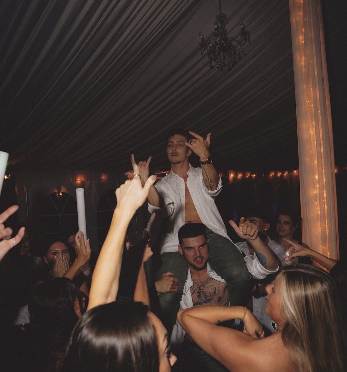 A guest lifted onto shoulders on the packed tent dance floor at Northfork Farm