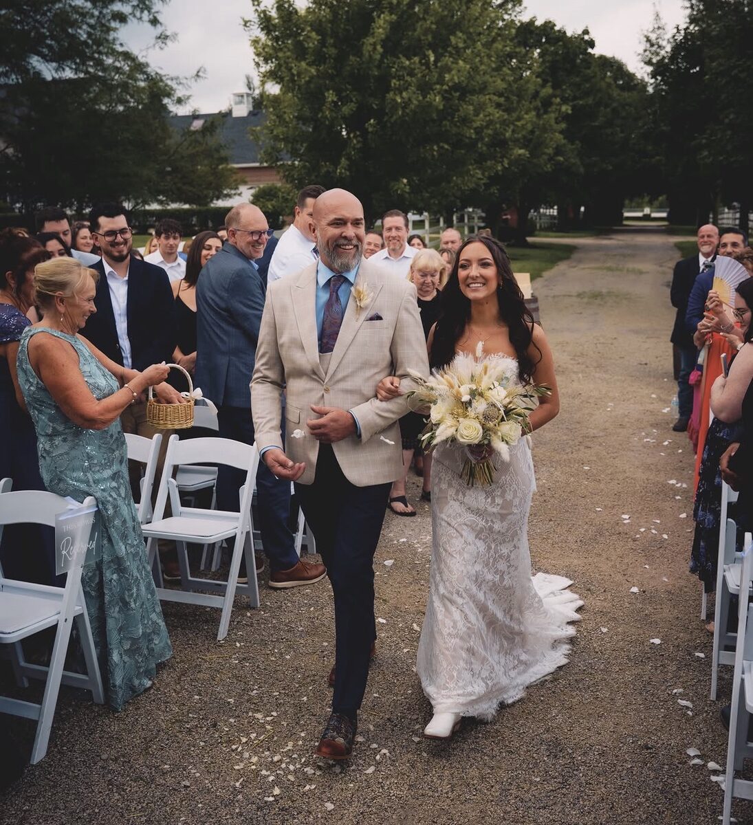 Jersey and her dad walking down the aisle at her outdoor wedding